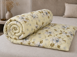 Folded yellow floral quilted comforter showing soft loft and floral print